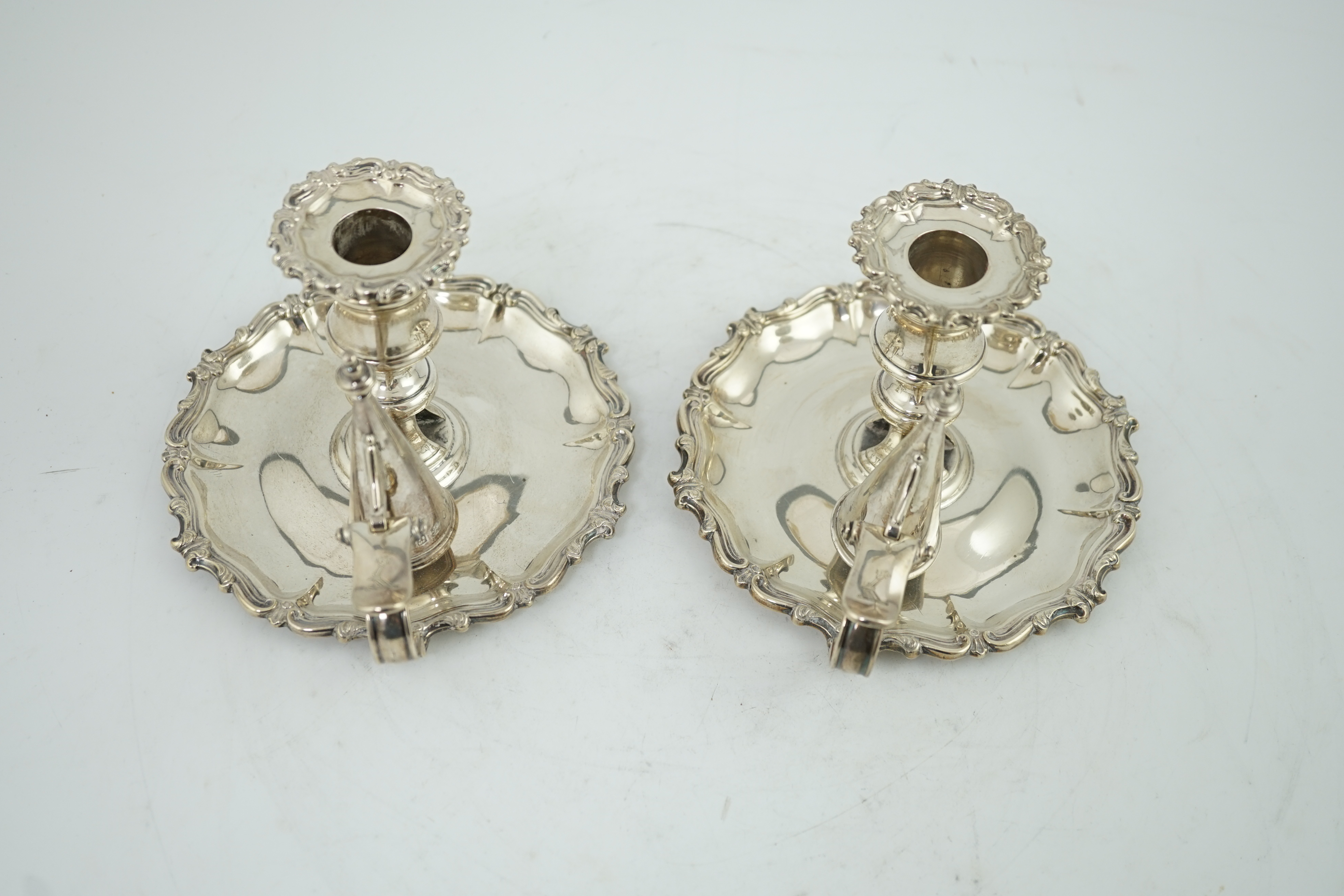 A pair of William IV silver chambersticks and extinguishers, by Creswick & Co